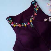 Close-up of hand embroidery on wine halter neckline