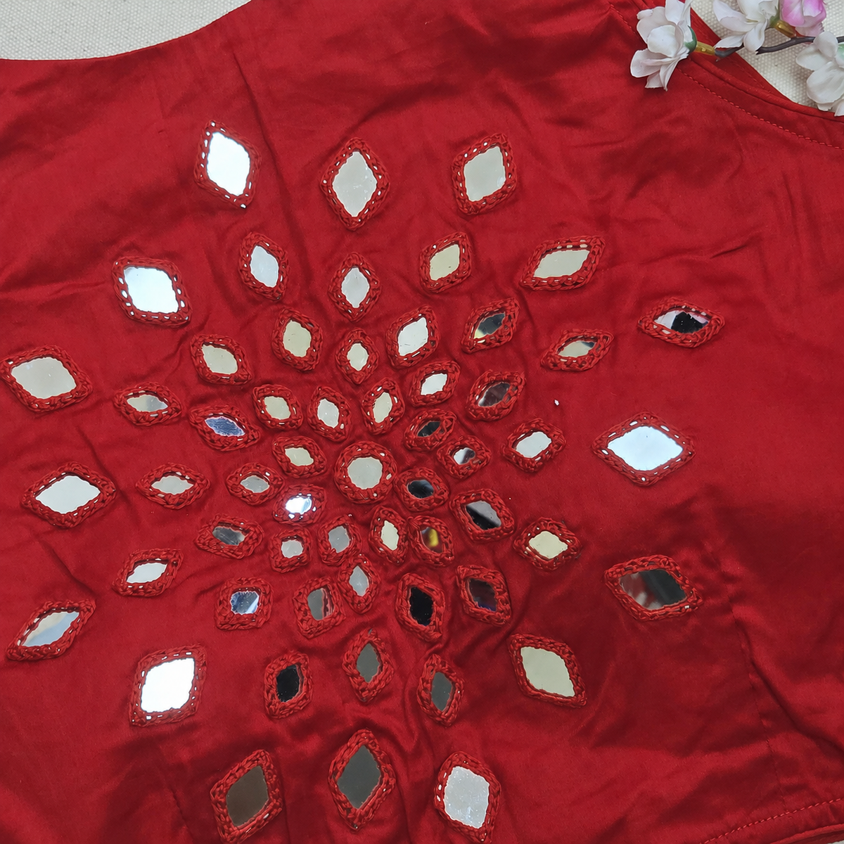 Close-up of hand mirror embroidery on red cotton silk